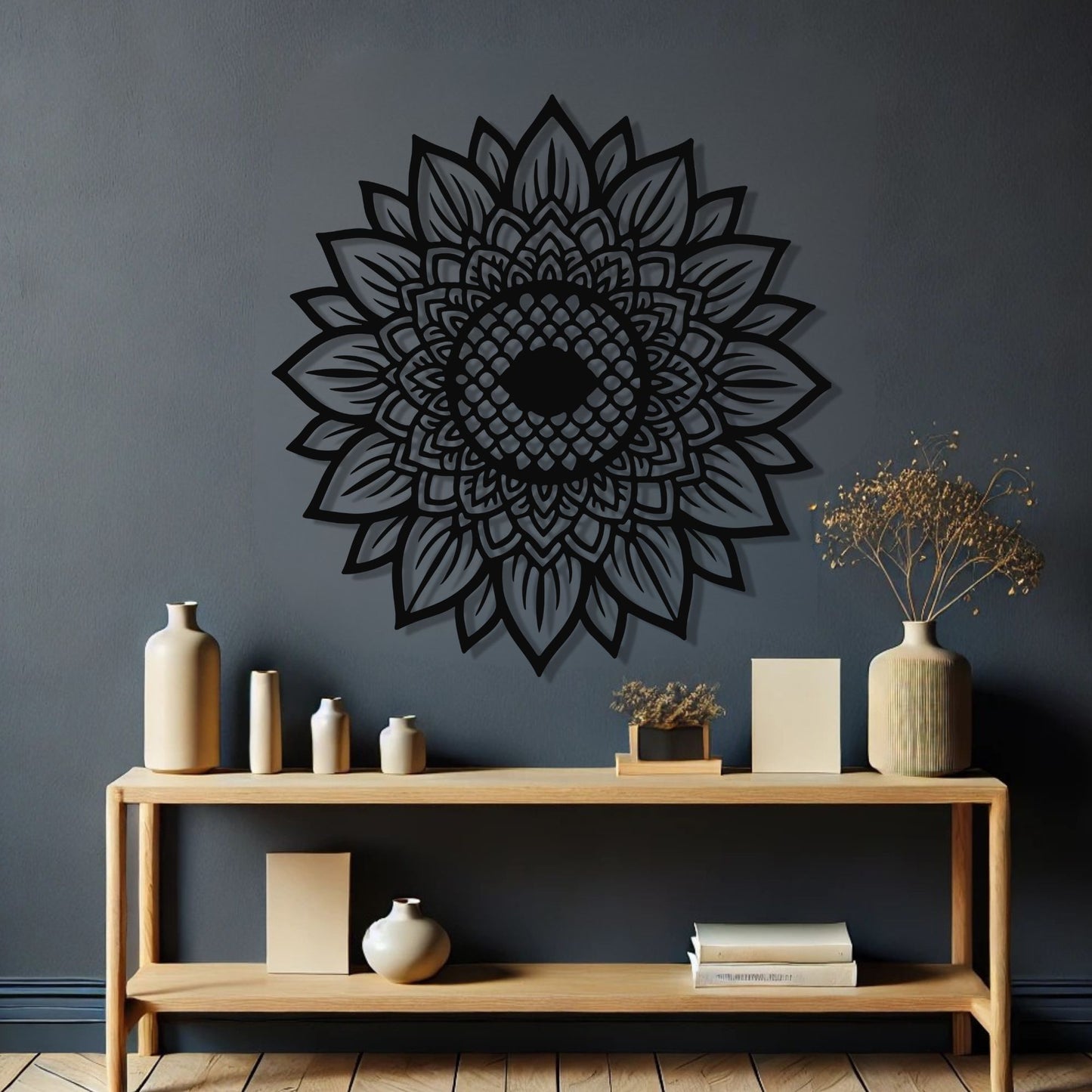 Decorative black mandala wall art on a dark gray wall with a wooden shelf below.