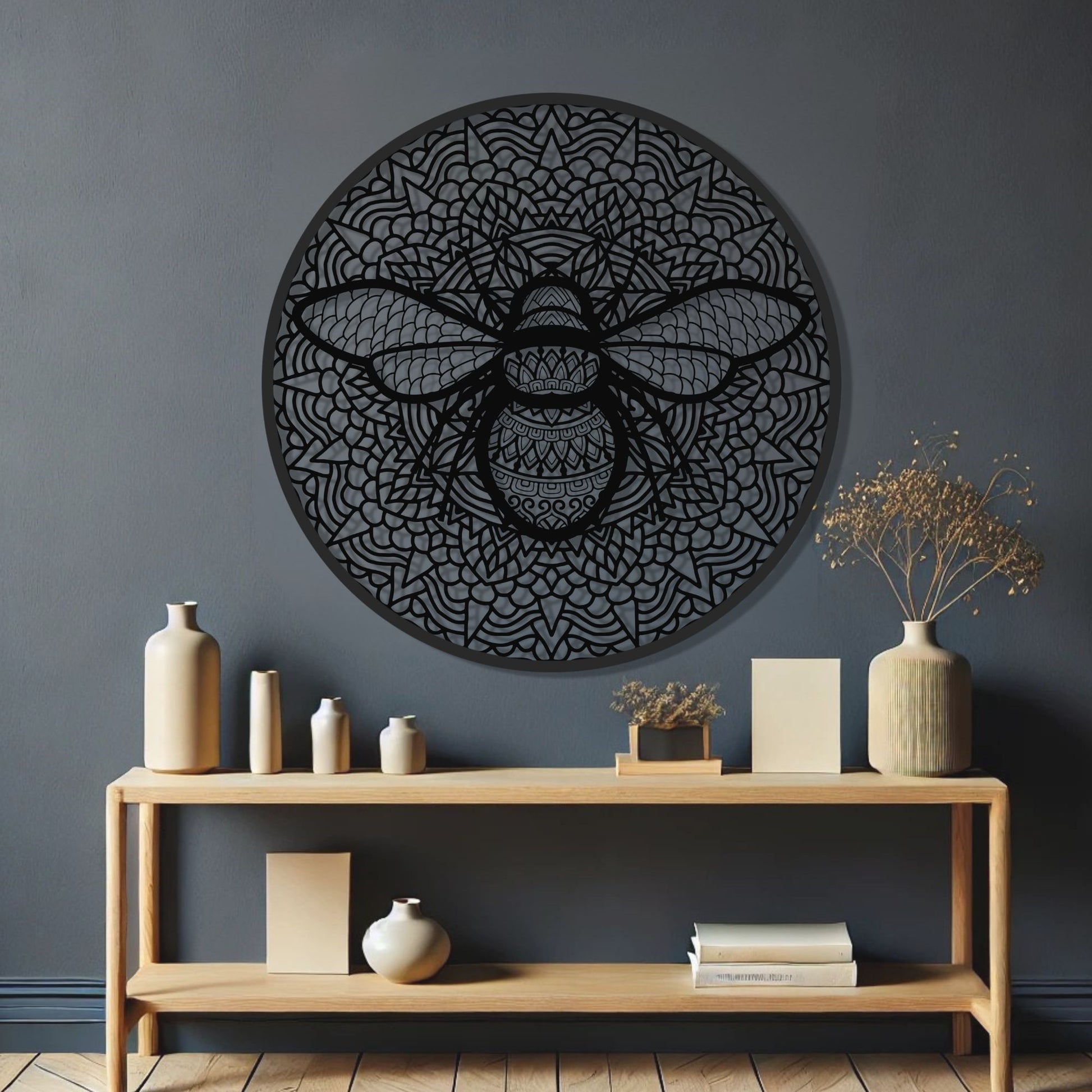 Decorative wall art of a bee on a dark wall above a wooden console table with decorative items.