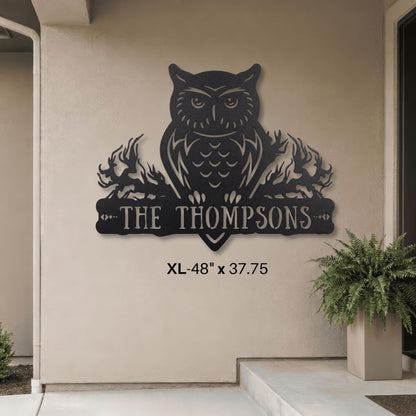 Decorative metal owl wall art with 'The Thompsons' text on a beige wall.