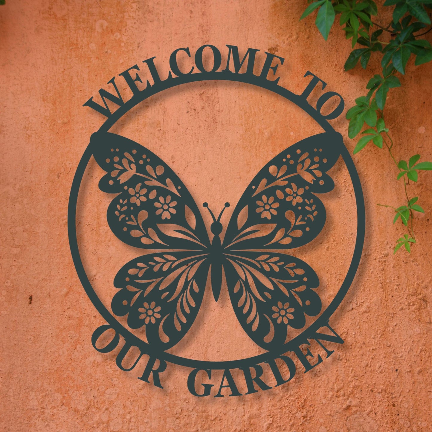 Decorative metal sign with butterfly design and 'Welcome to Our Garden' text on a textured wall.