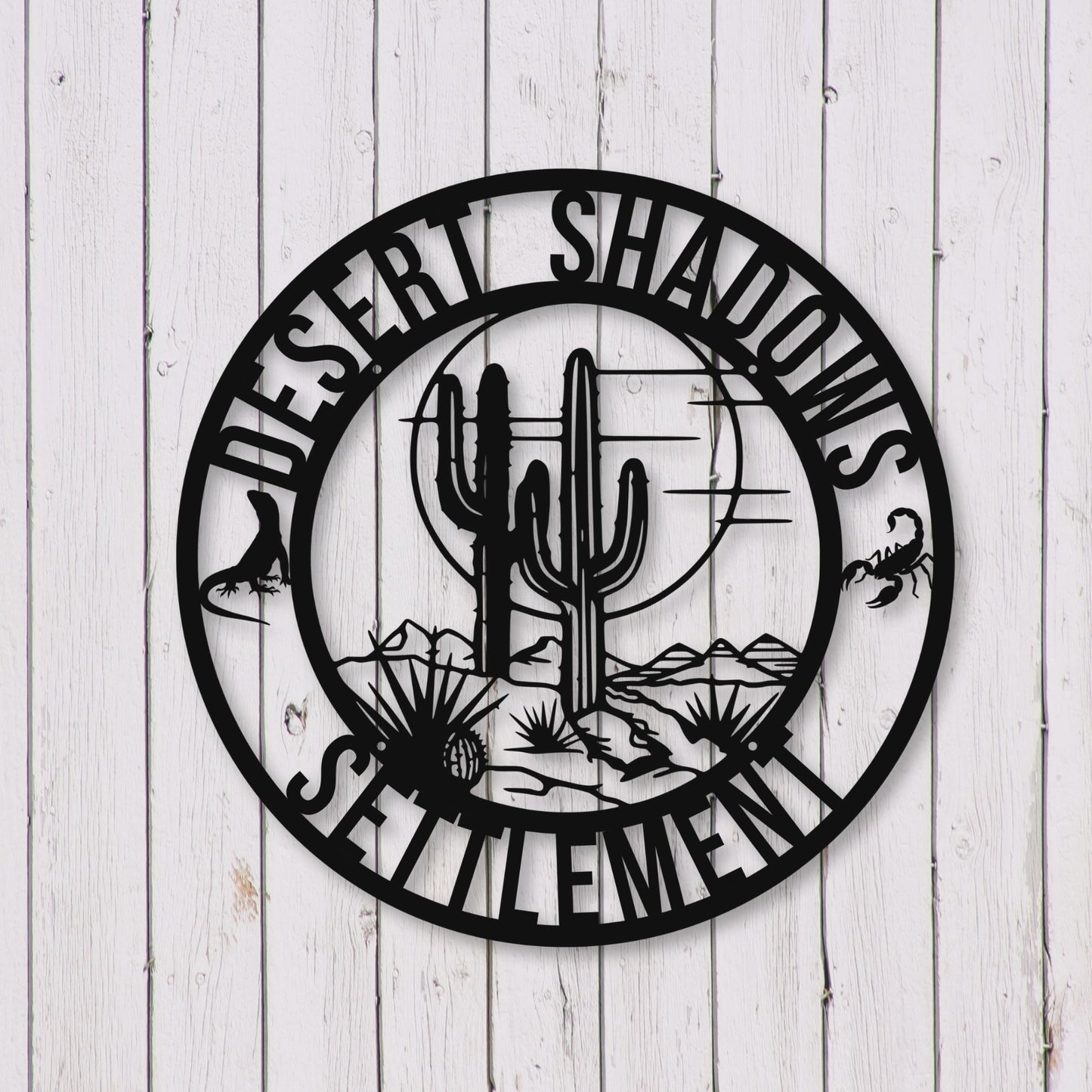 Decorative wall art with cactus design and 'Desert Shadows Settlement' text on a wooden background