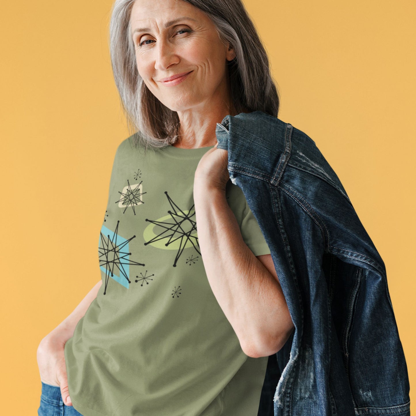 Woman wearing a green t-shirt with abstract designs on an orange background