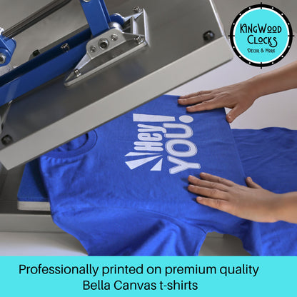 Blue t-shirt with white text being printed on a screen printing machine, with 'Kingwood Clocks' logo in the corner.