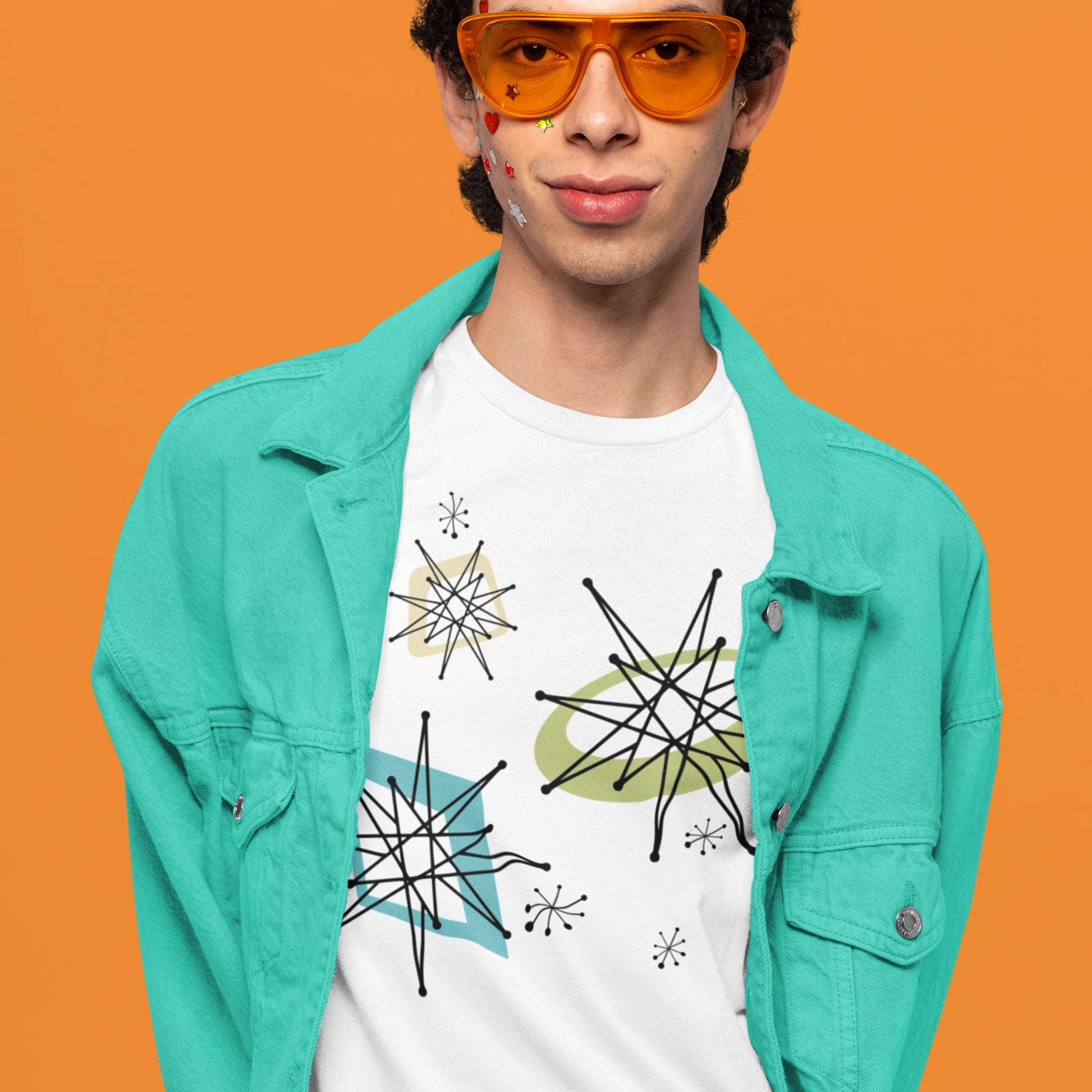 Person wearing a turquoise jacket and white t-shirt with star designs on an orange background