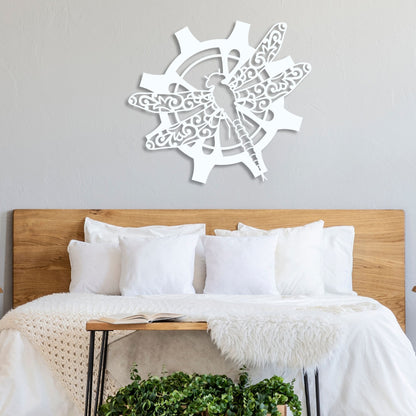Decorative wall art with a dragonfly design above a bed in a bedroom setting.