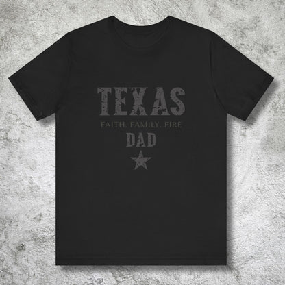 Black t-shirt with 'TEXAS FAITH FAMILY FIRE DAD' text on a textured gray background
