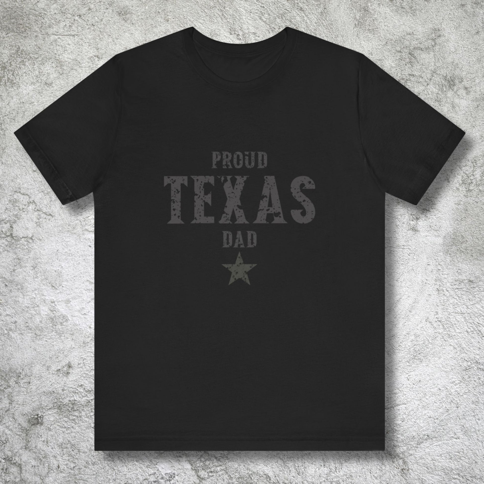 Black t-shirt with 'Proud Texas Dad' text on a textured gray background