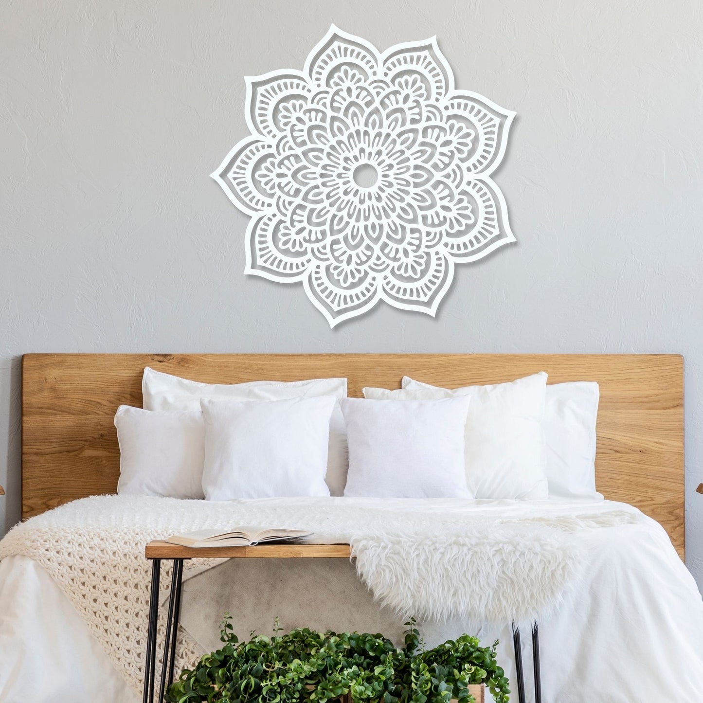 White mandala wall decal on a gray wall above a bed with wooden headboard and white bedding.