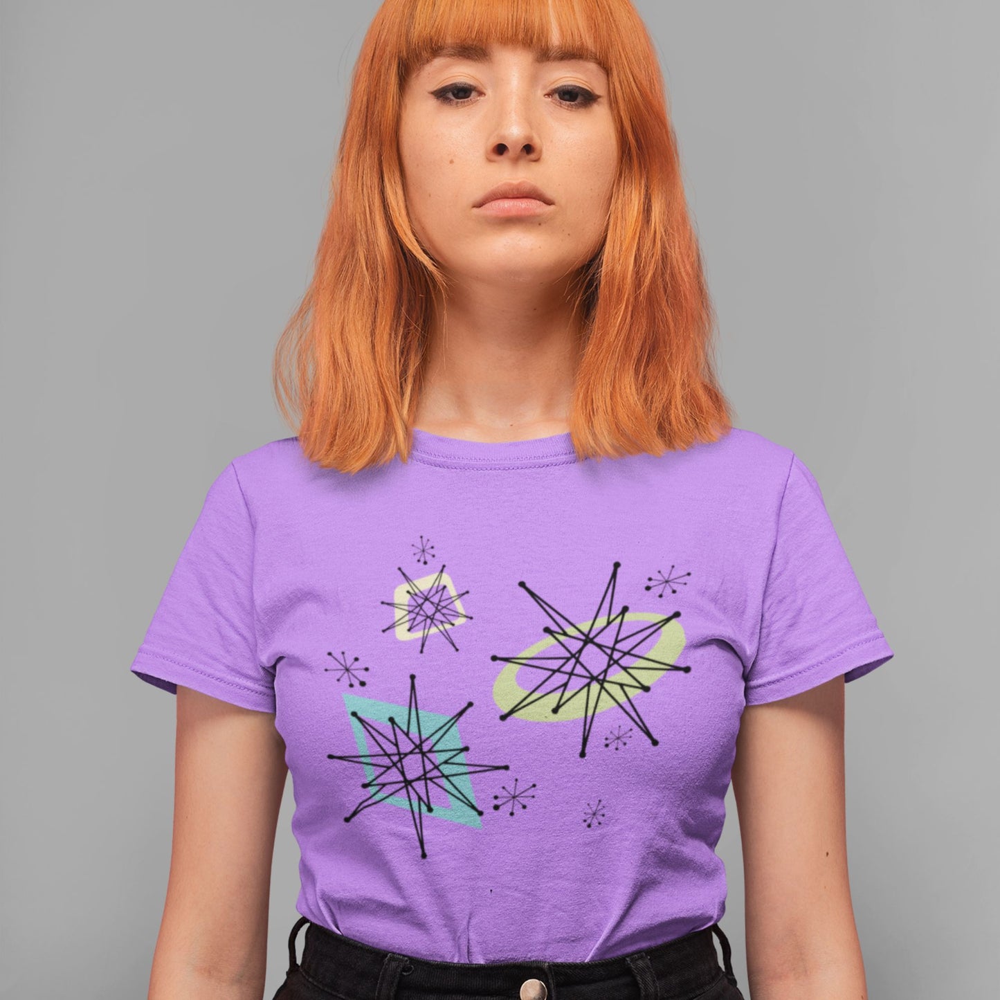 Person wearing a purple t-shirt with geometric designs on a gray background