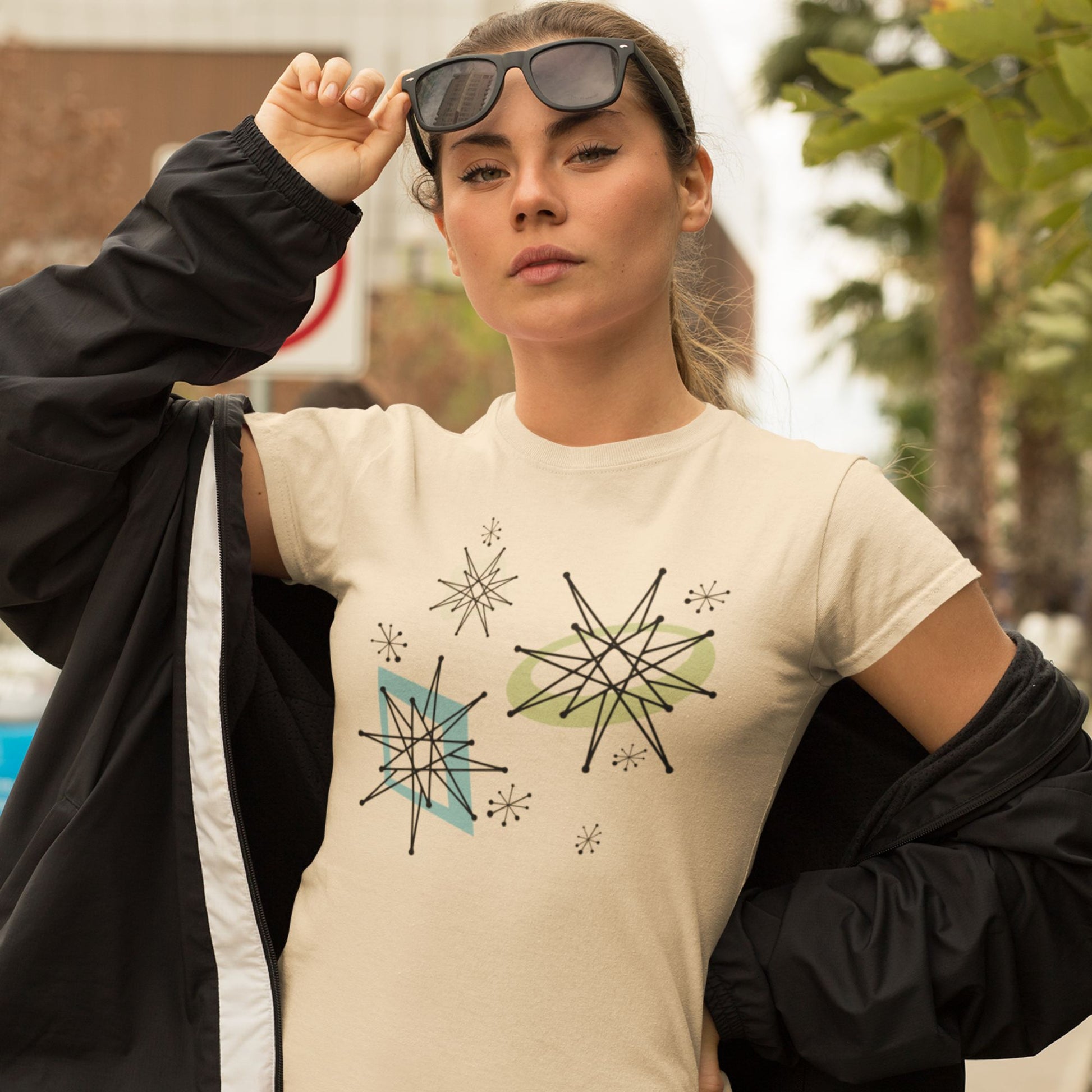 Woman wearing a beige t-shirt with geometric star designs outdoors