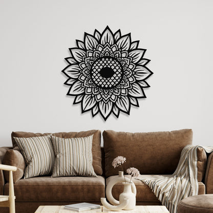 Decorative black mandala wall art on a white wall above a brown sofa.